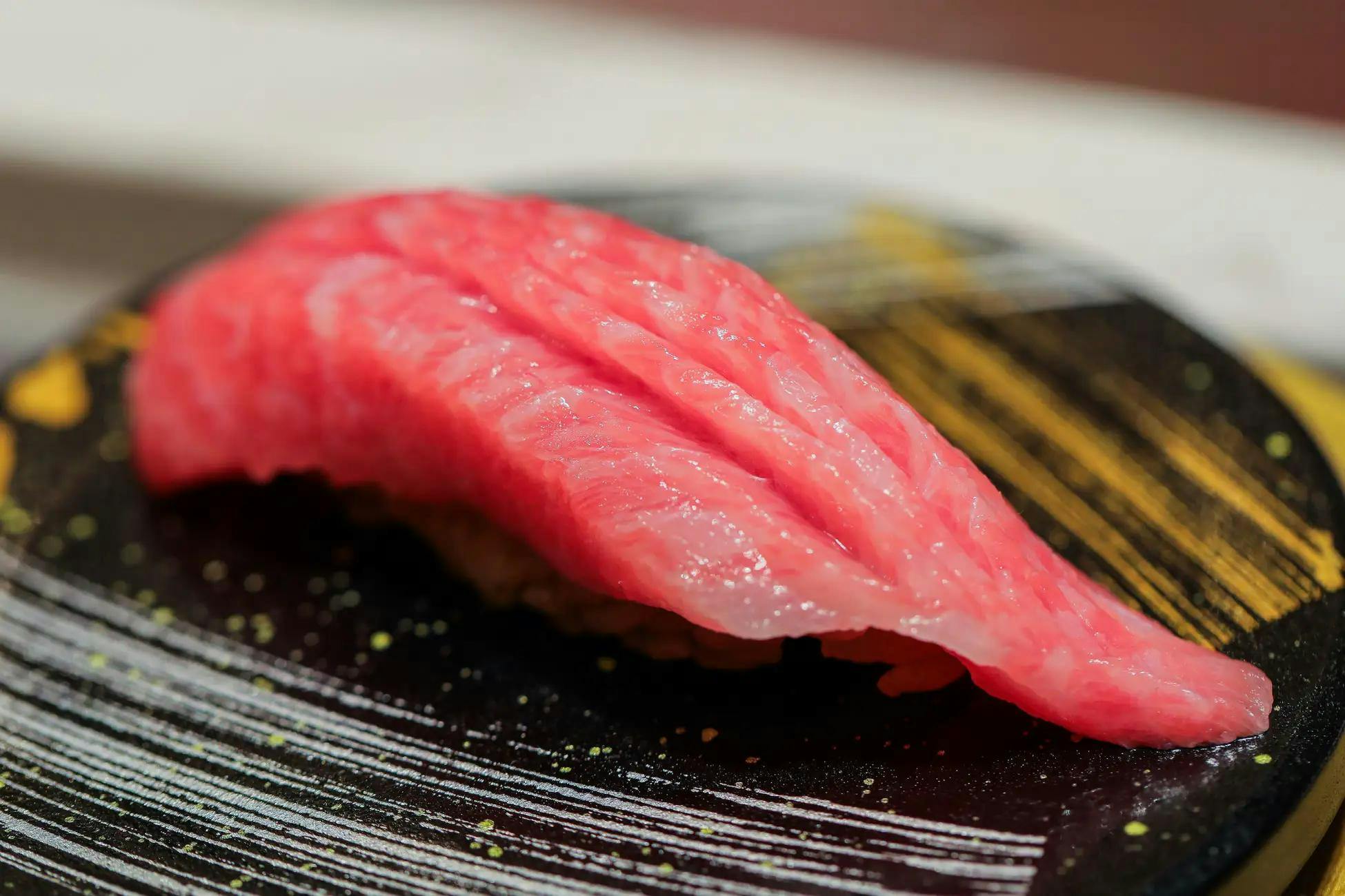 A piece of sushi with a tuna on top - made by a sushi chef in Ginza Onodera, Tokyo 