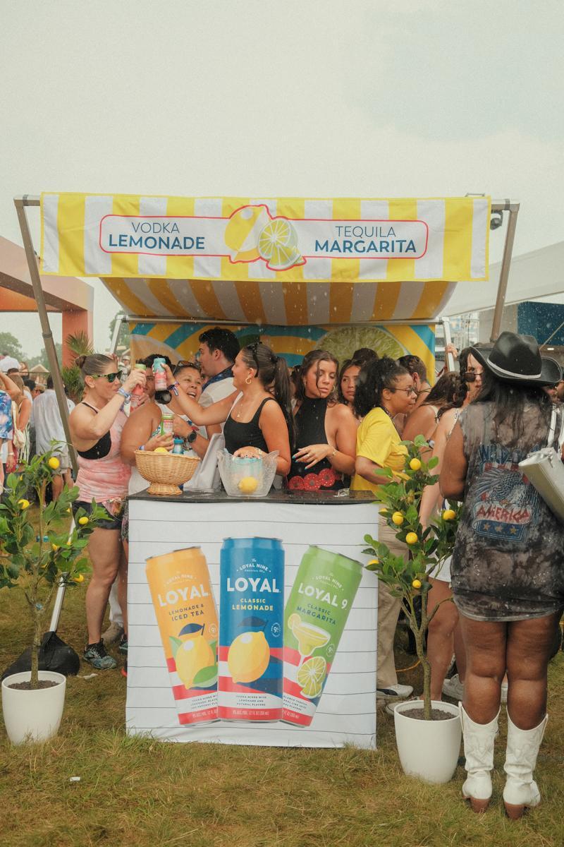 Palm Tree Festival attendees taking cover under a drink stand