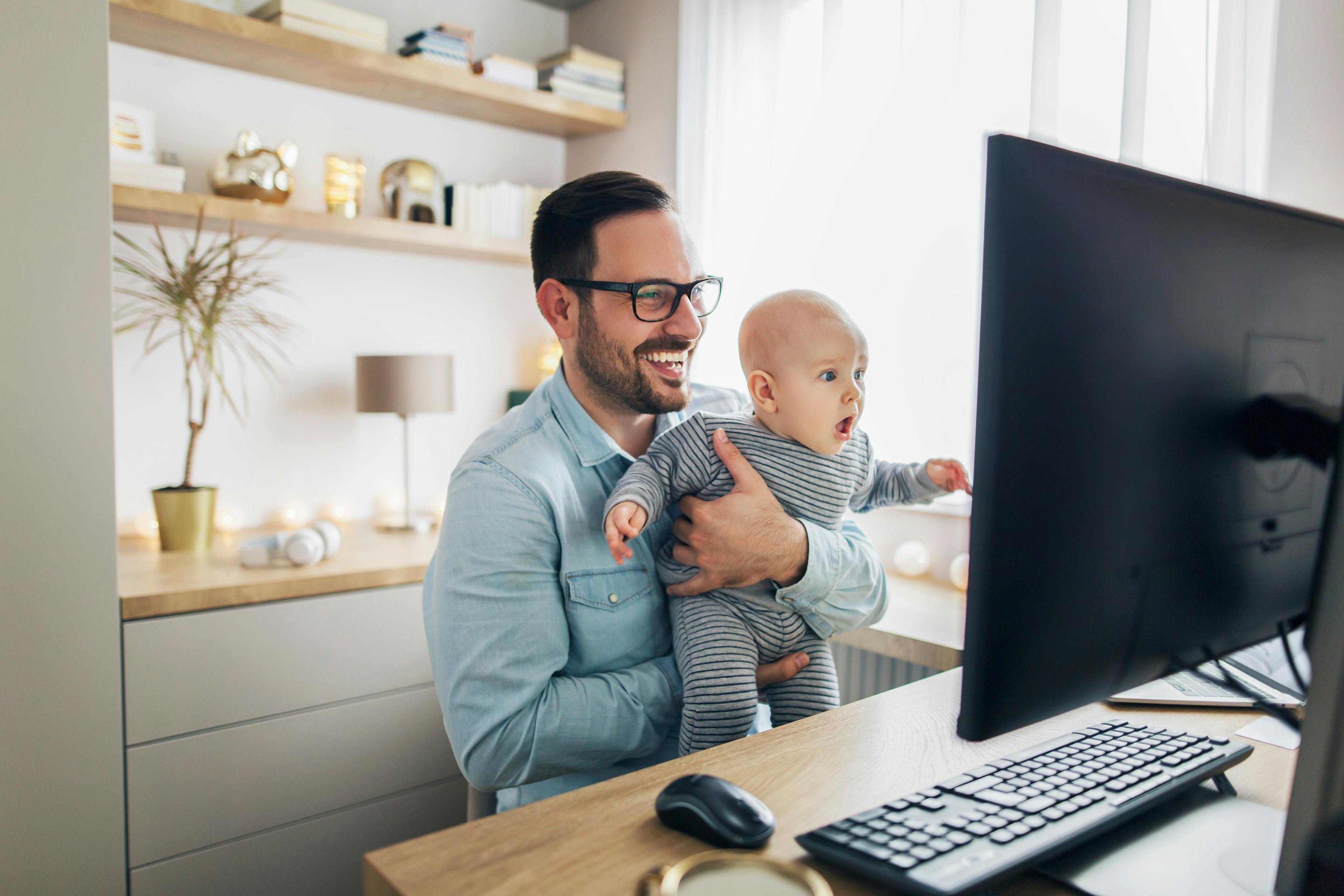 Demystifying digital marketing article header - A man holding his child in front of a monitor